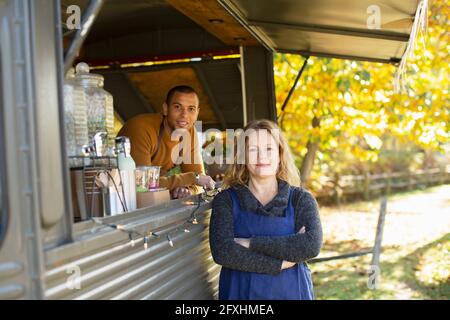 Portrait selbstbewusste Lebensmittelkarren-Besitzer im Herbstpark Stockfoto