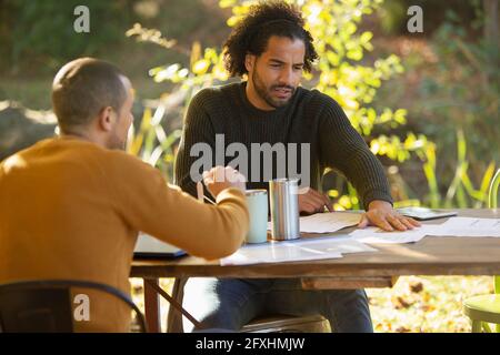 Geschäftsleute diskutieren Papierkram am Tisch im Park Stockfoto