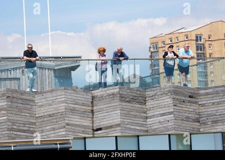 Hastings, East Sussex, Großbritannien. 27. Mai 2021. UK Wetter: Geschäftige Strandpromenade, da wärmeres Wetter und Sonnenschein die Menschen dazu bringen, das schöne Wetter zu genießen. Leute, die auf den Balkon am Hastings Pier blicken. Foto-Kredit: Paul Lawrenson /Alamy Live Nachrichten Stockfoto