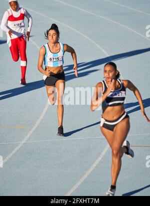 Leichtathletinnen, die im Wettkampf auf der Strecke laufen Stockfoto