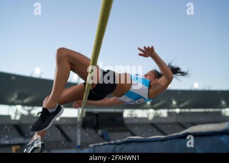 Leichtathletik-Sportlerin mit hohem Springen über die Pole Stockfoto