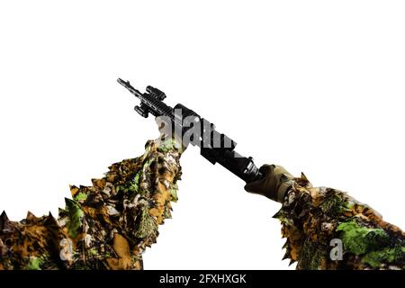 Isoliertes Foto einer ersten Person, die den Arm hält und mit einem Scharfschützengewehr im Guillie-Anzug auf weißem Hintergrund läuft. Stockfoto