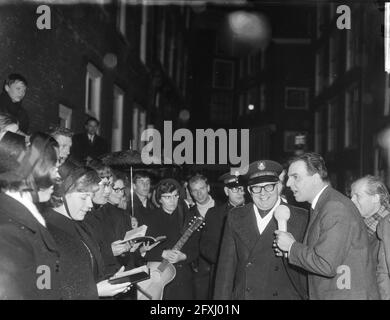 Willem Duys für sein Programm voor de vuist weg op Amsterdamse Zeedijk, hier im Gespräch mit Musikern der Heilsarmee, 23. Dezember 1965, Interviews, Niederlande, 20. Jahrhundert Presseagentur Foto, Nachrichten zu erinnern, Dokumentarfilm, historische Fotografie 1945-1990, visuelle Geschichten, Menschliche Geschichte des zwanzigsten Jahrhunderts, Momente in der Zeit festzuhalten Stockfoto