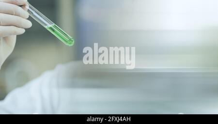 Zusammensetzung des Wissenschaftlers, der Reagenzglas mit grüner Flüssigkeit hält und Speicherplatz kopieren Stockfoto