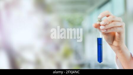 Zusammensetzung der Hand eines Labortechnikers, der das Reagenzglas mit blauer Flüssigkeit hält, mit verschwommenem Kopierraum Stockfoto