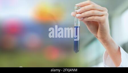 Zusammensetzung der Hand eines Laboranten, der das Reagenzglas mit blauer Flüssigkeit hält, mit farbigem Kopierraum Stockfoto