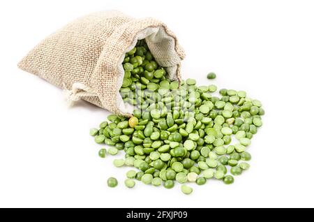 Bio-grüne Erbsen, die sich in einem Sack auf weißem Grund füllen. Stockfoto