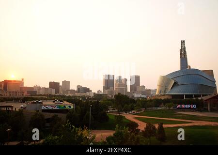 Sonnenuntergang über der Skyline von Winnipeg, Kanada. Das Canadian Museum for Human Rights steht auf der rechten Seite der urbanen Szene. Stockfoto