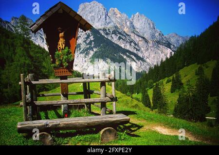 Bayerische Berglandschaft im Nationalpark Berchtesgaden, Deutschland, Europa. Wegekreuz mit Bank hoch in den Bayerischen Alpen, Bayern. Stockfoto