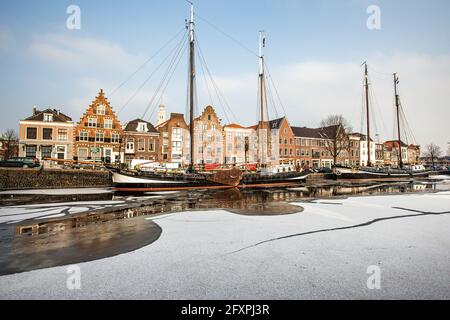 Hausfassaden und Boote, die im gefrorenen Kanal des Spaarne-Flusses, Haarlem, Amsterdam, Nord-Holland, Niederlande, Europa Stockfoto