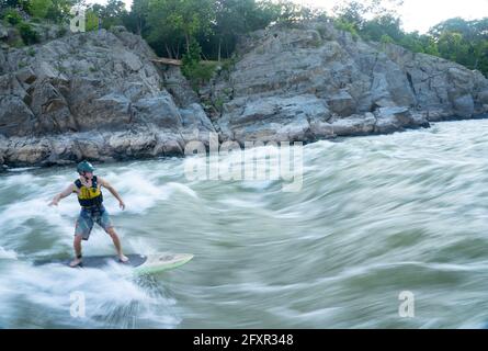 Ian Brown steht Up Paddle surft anspruchsvolles Wildwasser unter den Great Falls des Potomac River, der Grenze zwischen Maryland und Virginia, USA, Nordamerika Stockfoto