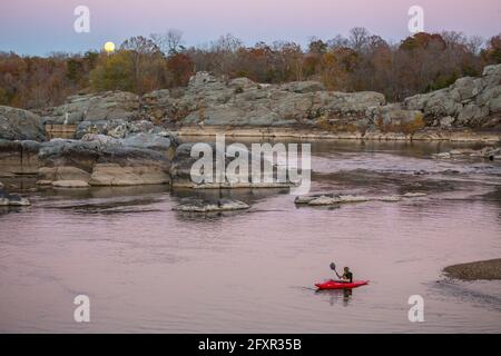 Ein Kind paddelt mit seinem Kajak auf dem Potomac River in Cabin John, um den aufgehenden Supermond vom 2016. November in Maryland, USA, Nordamerika zu beobachten Stockfoto