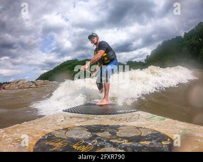 Der Fotograf Skip Brown Stand Up Paddle surft auf dem Potomac River, Maryland, Vereinigte Staaten von Amerika, Nordamerika, auf einer anspruchsvollen Wildwasserwelle Stockfoto