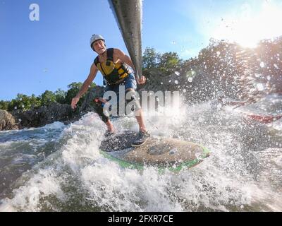 Der Fotograf Skip Brown steht auf dem Paddle unter den Great Falls des Potomac River, an der Grenze zwischen Virginia und Maryland, USA, in anspruchsvollem Wildwasser Stockfoto