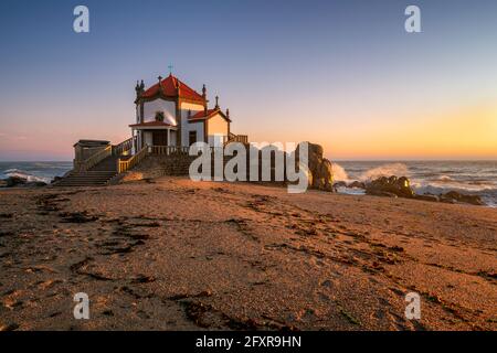 Schöne Kapelle von Capela do Senhor da Pedra am Strand bei Sonnenuntergang in Miramar, Vila Nova de Gaia, Portugal, Europa Stockfoto