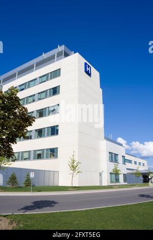 Modernes Krankenhaus gegen Himmel mit Wolken im Sommer geschossen Stockfoto