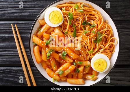 Koreanische Rabokki ist, was passiert, wenn Sie Tteokbokki mit Ramen Nudeln in der Schüssel auf dem Tisch mischen. Horizontale Ansicht von oben Stockfoto