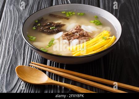 Koreanische Reiskuchen-Suppe Tteokguk für Neujahr in der Schüssel auf dem Tisch. Horizontal Stockfoto