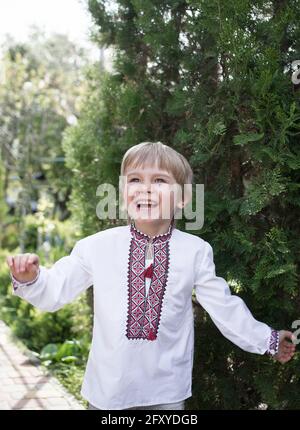 Lächelnder ukrainischer Junge 4-5 Jahre alt in einem bestickten Hemd mit der Emotion der Freude auf seinem Gesicht. Patriotische Erziehung. Symbol der Ukraine, Stolz, fredo Stockfoto