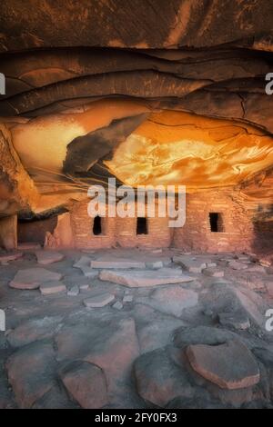 Reflektierendes Sonnenlicht beleuchtet die Decke dieses uralten Anasazi-Granars und trägt den treffenden Namen Falling Roof Ruin im Cedar Mesa Plateau im Südosten Utahs. Stockfoto