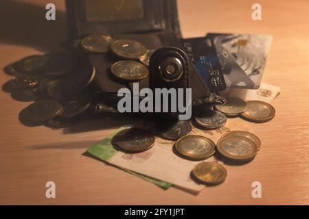 Geldbörse mit Plastikkarten und Bargeld auf dem Tisch. Stockfoto