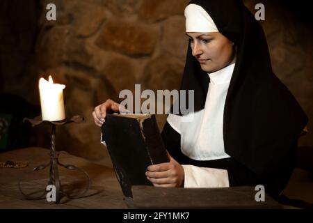 Junge Nonne nachdenklich mit alten bibel im alten Kloster Stockfoto