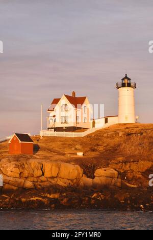 Blick über den Kanal auf den Nubble Lighthouse bei Sonnenuntergang in York, ME, USA Stockfoto