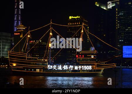 Wunderschön beleuchtetes Kreuzfahrtboot, das nachts auf dem Huangpu-Fluss am Bund in Shanghai, China, segelt Stockfoto