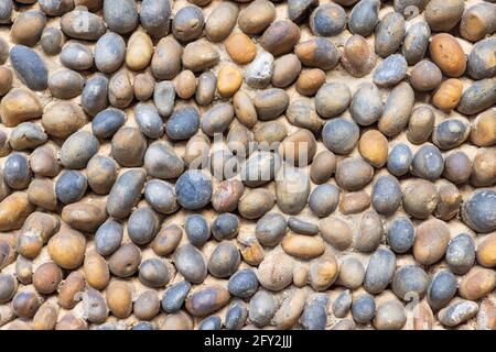 Nahaufnahme einer Steinmauer aus Strandkieseln. Hintergrundtextur. Stockfoto