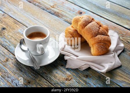 Blick von oben. Tasse heißen italienischen Espresso und Croissants auf hellblauem rustikalem Holzhintergrund. Essen und Trinken. Lifestyle. Stockfoto