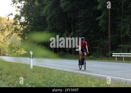Starker Kerl, der Fahrrad im Schutzhelm draußen reitet Stockfoto