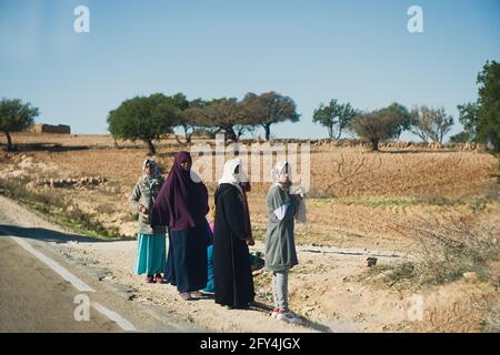 ESSAOUIRA, MAROKKO - 19. JANUAR 2020: Arme und einsame marokkanische Frauen stehen neben Felsen mit Nahrungsvorrat. Stockfoto