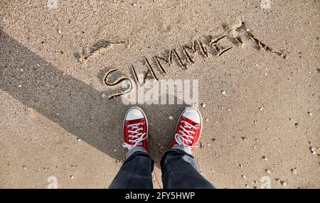 Auf dem Foto von oben, die Inschrift des Wortes Sommer auf nassem Sand von der Meereswelle gewaschen. Sommerferien Konzept Stockfoto