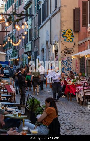 Rom, Italien - 26. Mai 2021: Trastevere, Straßen des historischen Stadtzentrums voller Touristen und Bürger, die an den Tischen im Freien sitzen Stockfoto