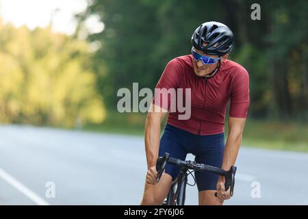 Muskulöser Mann in Helm und Brille Fahrrad fahren Stockfoto
