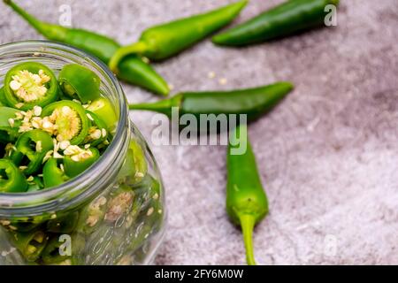 Peperoni und Jalapeno-Paprika platziert und mariniert in einem Glas Stockfoto