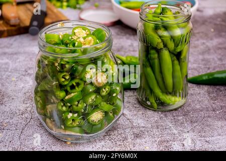 Peperoni und Jalapeno-Paprika platziert und mariniert in einem Glas Stockfoto