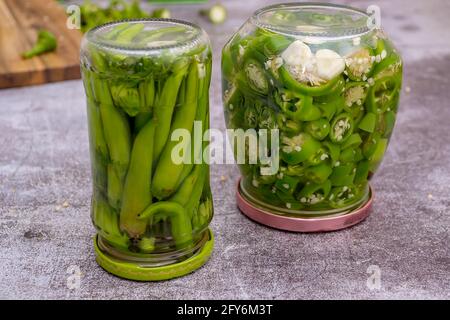 Peperoni und Jalapeno-Paprika platziert und mariniert in einem Glas Stockfoto