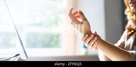 Junge Frau Mit Eingeklemmten Nervenschmerzen Am Büroschalter Stockfoto