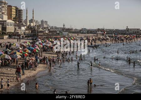 Gaza-Stadt, Palästinensische Gebiete. Mai 2021. Die Palästinenser genießen das Wasser entlang der Ufer des Mittelmeers, während das Leben wieder zur Normalität zurückkehrt, nachdem letzte Woche nach 11 Tagen tödlicher Konfrontationen zwischen Israel und der palästinensischen islamistischen Bewegung Hamas ein Waffenstillstand erreicht wurde. Kredit: Mohammed Talatene/dpa/Alamy Live Nachrichten Stockfoto