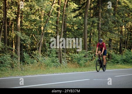 Junger Sportler auf dem Fahrrad im grünen Wald Stockfoto