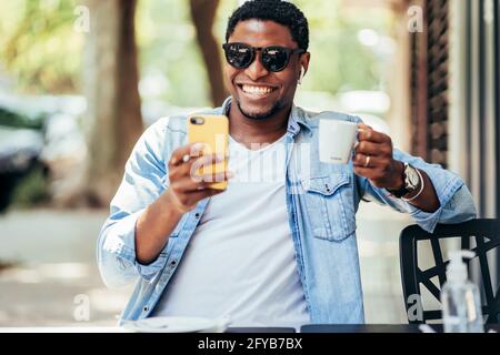 Mann auf einem Videoanruf mit einem Handy im Café. Stockfoto