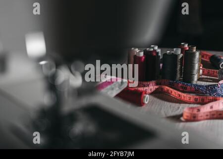 Bunte Fäden auf einem unscharfen dunklen Hintergrund. Selektiver Fokus. Stockfoto