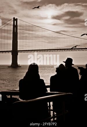 FÜNFZIGER JAHRE GOLDEN GATE BRIDGE BEI SONNENUNTERGANG DURCH SILHOUETTEN ANONYM BEOBACHTET PASSAGIERE AN DECK DER FÄHRE SAN FRANCISCO CA USA - B5939 HAR001 HARS KOPIEREN RAUM HALBE LÄNGE DAMEN GOLDEN PERSONS INSPIRATION MÄNNER SCHIFFE SILHOUETTEN SPIRITUALITÄT TRANSPORT B&W FRANCISCO OUTLINE GATE FLÜGEL KOPF UND SCHULTERN ABENTEUER ENTDECKUNG SILHOUETTEN UND AUFREGUNG AN DURCH VON AUF CA-VERBINDUNG WESTKÜSTEN-FÄHRE MÖWEN ANONYM SAN FRANCISCO GEFIEDERTE SCHIFFSSPANNE GEFLÜGELTE SCHWARZ-WEISSE BRÜCKEN GOLDEN GATE HAR001 VERBINDEN ALTMODISCH Stockfoto