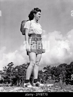 1930ER-JAHRE LÄCHELND ATHLETISCHE TEENAGER-MÄDCHEN MIT SPALTGETEILTEM HOLZ WANDERN BASKET RUCKSACK SOMMER SHORTS SATTEL OXFORD SCHUHE - H647 HAR001 HARS JUGENDLICHER STIL GESUNDE SPORTLER LEBENSSTIL ZUFRIEDENHEIT FRAUEN LÄNDLICHE GESUNDHEIT LEICHTATHLETIK KOPIEREN RAUM IN VOLLER LÄNGE KÖRPERLICHE FITNESS PERSONEN SATTEL TEENAGER MÄDCHEN SPORTLICHE WANDERUNG B&W SPLIT BRUNETTE FREIHEIT AKTIVITÄT GLÜCK KÖRPERLICHES ABENTEUER DISCOVERY FREIZEIT STÄRKE WANDERER LOW ANGLE ERHOLUNG RICHTUNG SATTEL OXFORDS OXFORD ATHLETEN FLEXIBILITÄT MUSKELN TEENAGERALTER WACHSTUM JUGENDLICHE ENTSPANNUNG GEWEBTER RUCKSACK SCHWARZ-WEISS KAUKASISCHE ETHNIZITÄT HAR001 ALTMODISCH Stockfoto