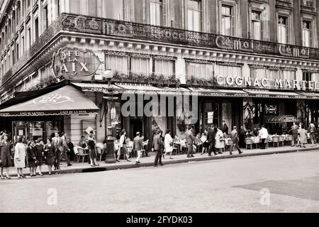 60ER JAHRE CAFE DE LA PAIX AUF DEM PLACE DE L'OPERA UND FUSSGÄNGER IN DER RUE DE LA PAIX UND GÄSTE IM CAFÉ IM FREIEN TABELLEN PARIS FRANKREICH - R18865 MAY001 HARS REAL ESTATE DE STRUKTUREN STÄDTE GOURMET-GEBÄUDE OPULENT 9. ARRONDISSEMENT CAFE DE LA PAIX DINERS PAIX PLACE DE L'OPERA ERFRISCHUNG STRASSENSZENE SCHWARZ UND DAS WEISSE, ALTMODISCHE PARISER LA Stockfoto