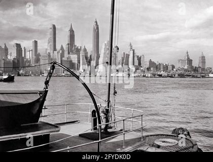 BLICK AUF DIE SKYLINE DER LOWER MANHATTAN ISLAND AUS DEN 1940ER JAHREN MIT WOLKENKRATZERN VON DECK DES SCHIFFES IN BROOKLYN NEW YORK CITY ANGEDOCKT NY USA - R2042 HAR001 HARS NORTH AMERICA HARBOUR DOWNTOWN NORDAMERIKANISCHE STRUKTUR IMMOBILIEN AUSSEN IN DER NYC IMMOBILIEN ANGEDOCKT NEW YORK STRUKTUREN STÄDTE GEBÄUDE NEW YORK CITY FRACHTER VERSAND WOLKENKRATZER SCHWARZ UND WEISS HAR001 ALTMODISCHE SCHIFF Stockfoto