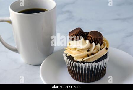 Schokolade Erdnussbutter Tasse Kuchen mit einer Tasse Kaffee Stockfoto