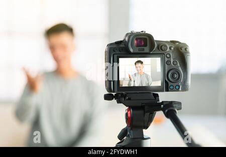 Junger Mann, der Video für eine Internetreportage oder ein Tutorial aufzeichnet Streaming Stockfoto