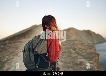 Die Touristenfrau steigt an der Spitze der Bar entlang Die Straße mit einem Rucksack auf dem Rücken Stockfoto